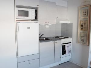 阿卡斯洛姆波罗TaloYlläs, Huonemajoitus的厨房配有白色冰箱和微波炉