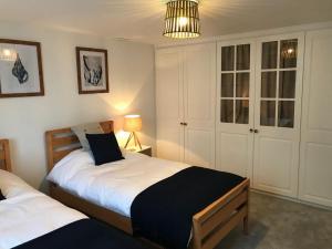 滨海韦斯顿Hill Cottage的一间卧室配有两张床和一盏灯