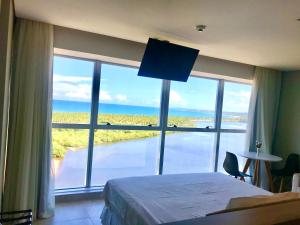 累西腓Paiva Flat Home Stay - Barra de Jangada的卧室设有海景大窗户