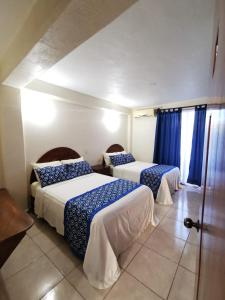 锡瓦塔塔内霍Habitaciones del Pacifico的酒店客房设有两张床和窗户。