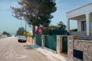 玛丽娜迪曼卡维萨Villetta Lungomare Gallipoli - Family House的停在围栏旁街道边的汽车