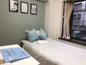 东京Fact Dream House 新宿三丁目徒歩3分色々揃うワンルーム的一间卧室配有一张床,上面有一本书