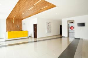 雅加达特贝特阿马里斯酒店的大房间设有白色的墙壁和木制天花板
