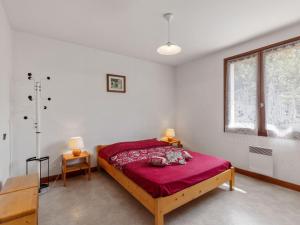 MontagnyModern Holiday Home in Montagny with Balcony的一间卧室配有一张带红色毯子的床