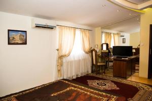 利兹文罗科酒店的客房设有带书桌和窗户的卧室。