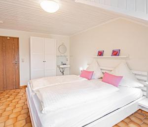 Mesenich约翰尼舍夫葡萄酒咖啡厅和旅馆的卧室配有带粉红色枕头的大型白色床