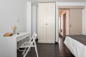 马拉加HOMEABOUT LA MERCED Duplexes的白色卧室配有书桌和床