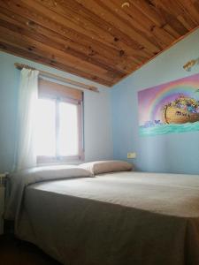 MontánCasa Rural Los Pineros的卧室配有一张带彩虹画的床铺,墙上挂着彩虹画