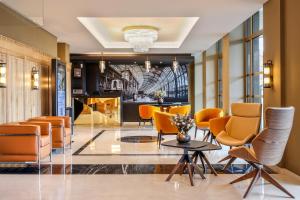 斯特拉斯堡Hotel des Vosges BW Premier Collection的大堂配有橙色椅子和桌子