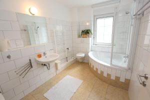 纽伦堡托门公寓的白色的浴室设有浴缸和水槽。
