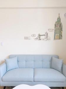 台南have fun ! 花園夜宿的客厅里一张蓝色的沙发,墙上挂着画