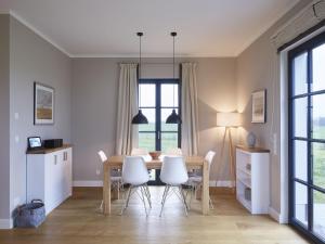 德兰斯克Reetland am Meer - Premium Reetdachvilla mit 3 Schlafzimmern, Sauna und Kamin F10的厨房以及带桌椅的用餐室。