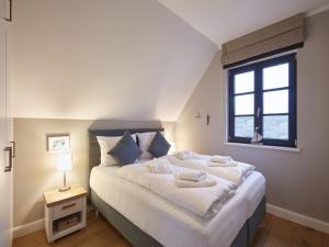德兰斯克Reetland am Meer - Premium Reetdachvilla mit 3 Schlafzimmern, Sauna und Kamin F10的卧室配有一张大白色床和窗户