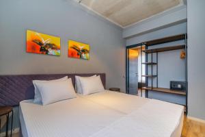乌雷基Magnetic Resort Ureki的卧室配有一张白色床,墙上挂有两幅画作