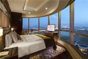 漳州漳州皇冠假日酒店的一间卧室设有一张大床和一个大窗户