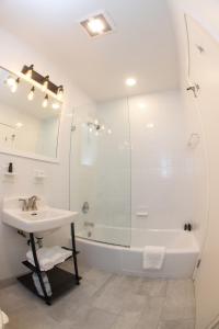 斯特拉特福德The Surfside Hotel的白色的浴室设有水槽和淋浴。