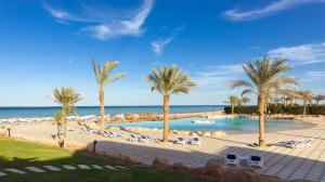 赫尔格达Gravity Hotel & Aqua Park Sahl Hasheesh Families and Couples Only的一座种有棕榈树和椅子的游泳池