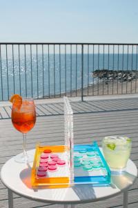 斯特拉特福德The Surfside Hotel的阳台上的桌子上放着饮料和眼镜
