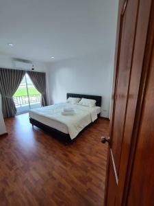 Ban Khlong KrangYYK Homestay的一间卧室配有一张床,铺有木地板