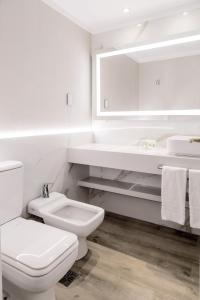 罗萨里奥罗萨里奥假日酒店的白色的浴室设有卫生间和水槽。
