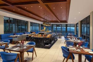 达兰萨拉Storii By ITC Hotels, Amoha Retreat Dharamshala的一间带桌椅的餐厅以及一间自助餐