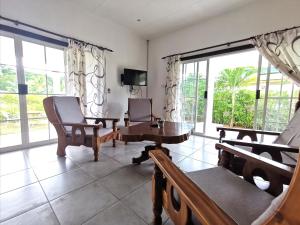 拉迪格岛CHEZ MARVA Grande Villa COCO 3 à 12 personnes的客厅配有椅子和桌子,设有窗户