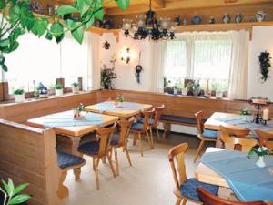 布兰德Landhaus-Pension Zum Waffenschmied的餐厅设有木桌、椅子和窗户。