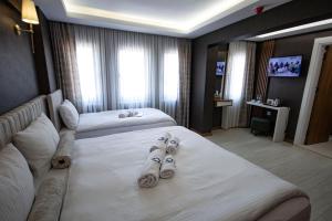 伯萨KAR BEYAZ HOTEL BURSA的酒店的客房 - 带两张床和拖鞋