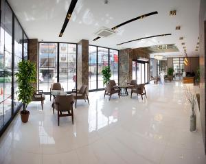 伯萨KAR BEYAZ HOTEL BURSA的大型大堂设有桌椅和窗户。