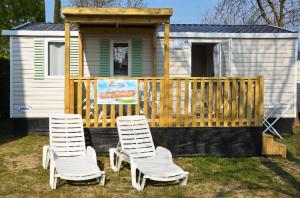 洛特佐拉伊Happy Camp Mobile Homes in Camping Iscrixedda的两把椅子坐在一个小房子前面