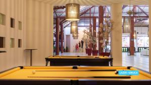 托鲁斯Vila Galé Resort Touros - All Inclusive的一组台球桌,房间背景的人