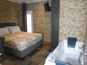 塞萨洛尼基Luxury Living Apartments and Spa的一间卧室配有一张床和一个浴缸,浴缸旁边设有一个水槽