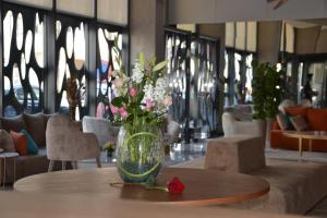 拉巴特Flower Town Hotel & Spa的花瓶,花朵放在桌子上