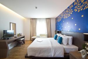 乔木提恩海滩芭堤雅乔木提恩特万酒店的酒店客房,设有床铺和蓝色的墙壁