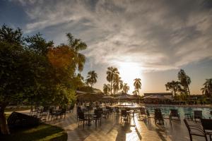 伊瓜苏Grand Carimã Resort & Convention Center的一个带桌椅的游泳池以及阳光环境