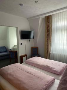 克洛滕Cafe Moselterrasse的酒店客房设有两张床和一台平面电视。