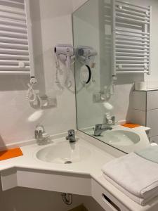 克洛滕Cafe Moselterrasse的一间带水槽和镜子的浴室