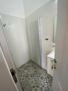 提比里亚יחידת נופש בבית ורדי的带淋浴的小浴室和瓷砖地板。