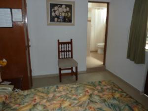 库埃纳瓦卡巴霍埃尔博尔坎酒店的一间卧室配有一张床、一把椅子和一个卫生间