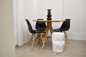 巴里First Floor B&B的一张桌子、一张黑色的椅子和一张带花瓶的桌子