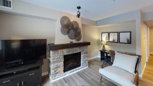 戴德曼斯弗莱斯Copperstone Resort的客厅设有壁炉和平面电视。