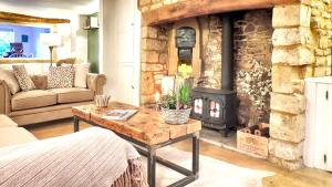 莫顿因马什Magnolia Cottage的客厅设有石制壁炉和桌子。