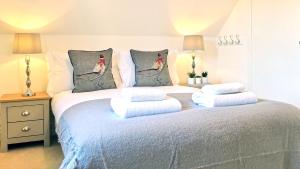 莫顿因马什Magnolia Cottage的一间卧室配有带四个枕头的床