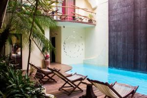 普拉亚卡门基贝酒店的一组椅子坐在游泳池旁