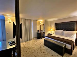 韦林格勒Maxi Park Hotel & Spa的酒店客房设有一张大床和一张书桌。