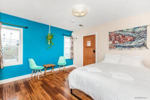 圣地亚哥Samesun Ocean Beach Hotel & Hostel的一间拥有蓝色墙壁的卧室,配有一张床和两把椅子