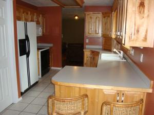 西黄石Geyser Mountain Home的厨房配有木制橱柜和白色冰箱。