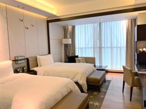 南昌南昌绿地华邑酒店的酒店客房带两张床和一个客厅