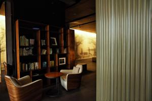 杭州杭州心隅设计师酒店 - 近地铁口,书香江南简约多元设计的一间设有两把椅子的房间和一个带书籍的书架