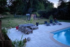 BaronLogement 2/4 pers-piscine-25mn rocade bordeaux的游泳池旁带躺椅的庭院